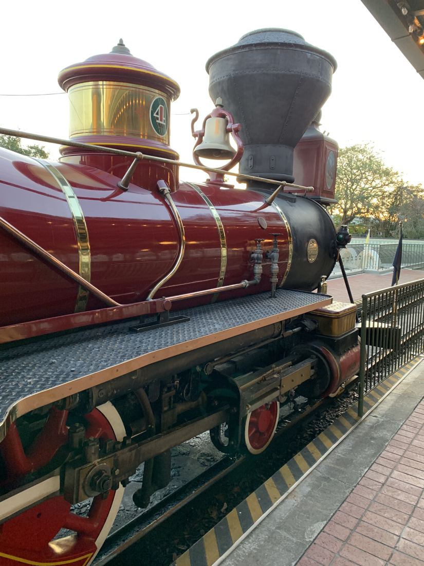 Red and brass steam locomotive at a station platform