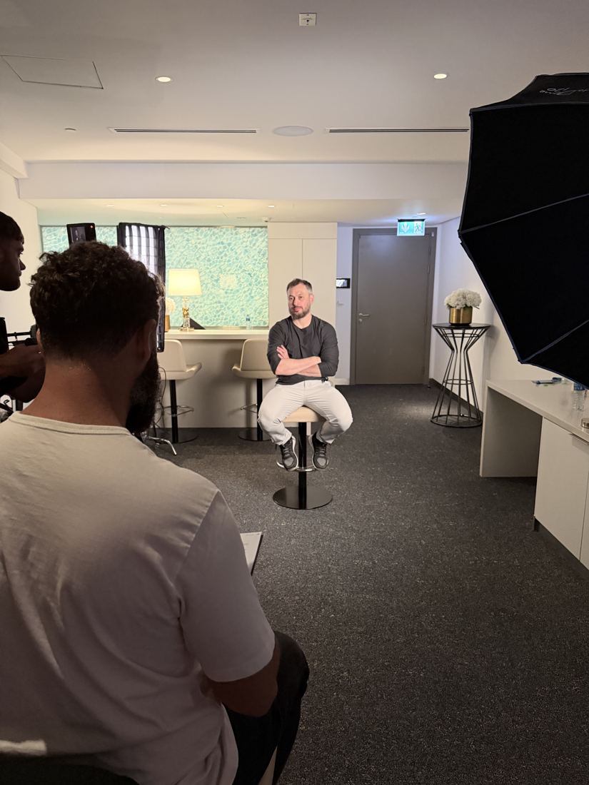 Interview setup with a seated guest, softbox and crew