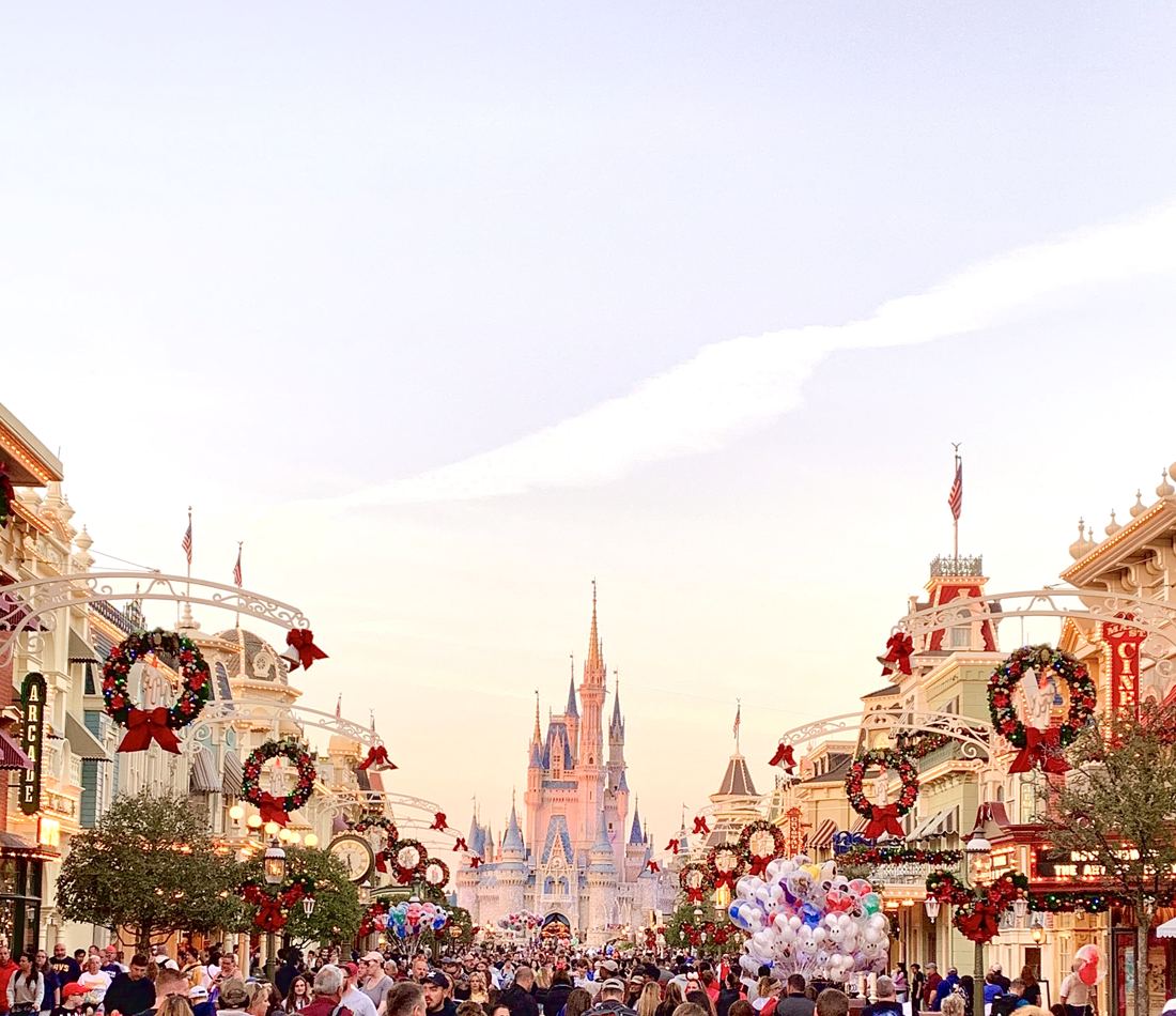 A decorated main street leading to a castle at dusk