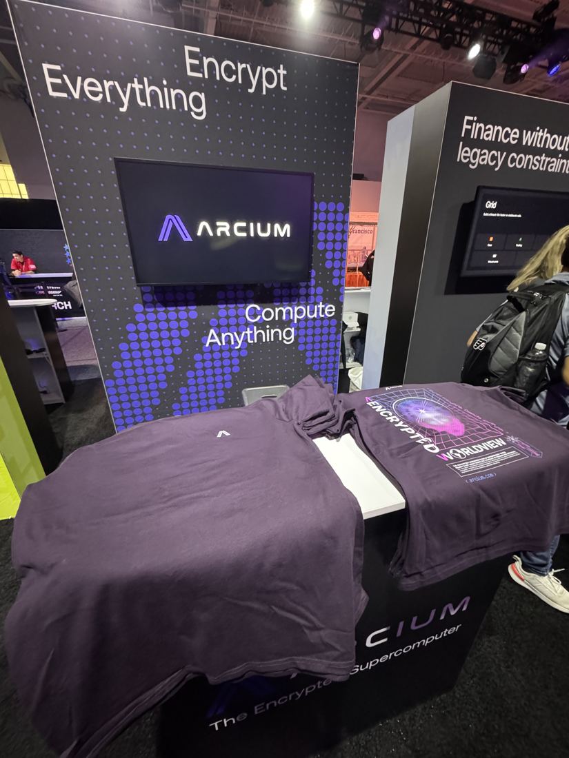 Arcium shirts laid out at a conference booth